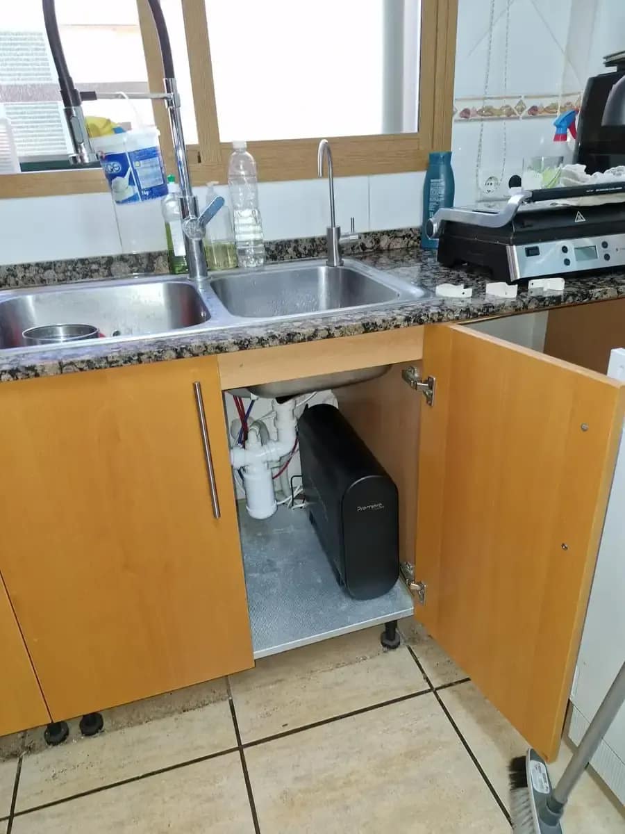 Premier 3.0 en un mueble de madera bajo el fregadero, con grifo auxiliar junto al grifo extensible